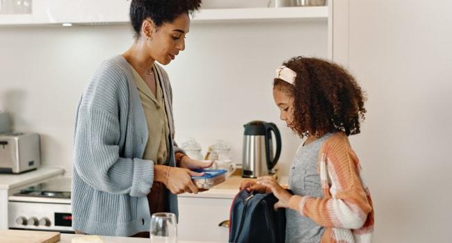 mom and daughter packing school lunch