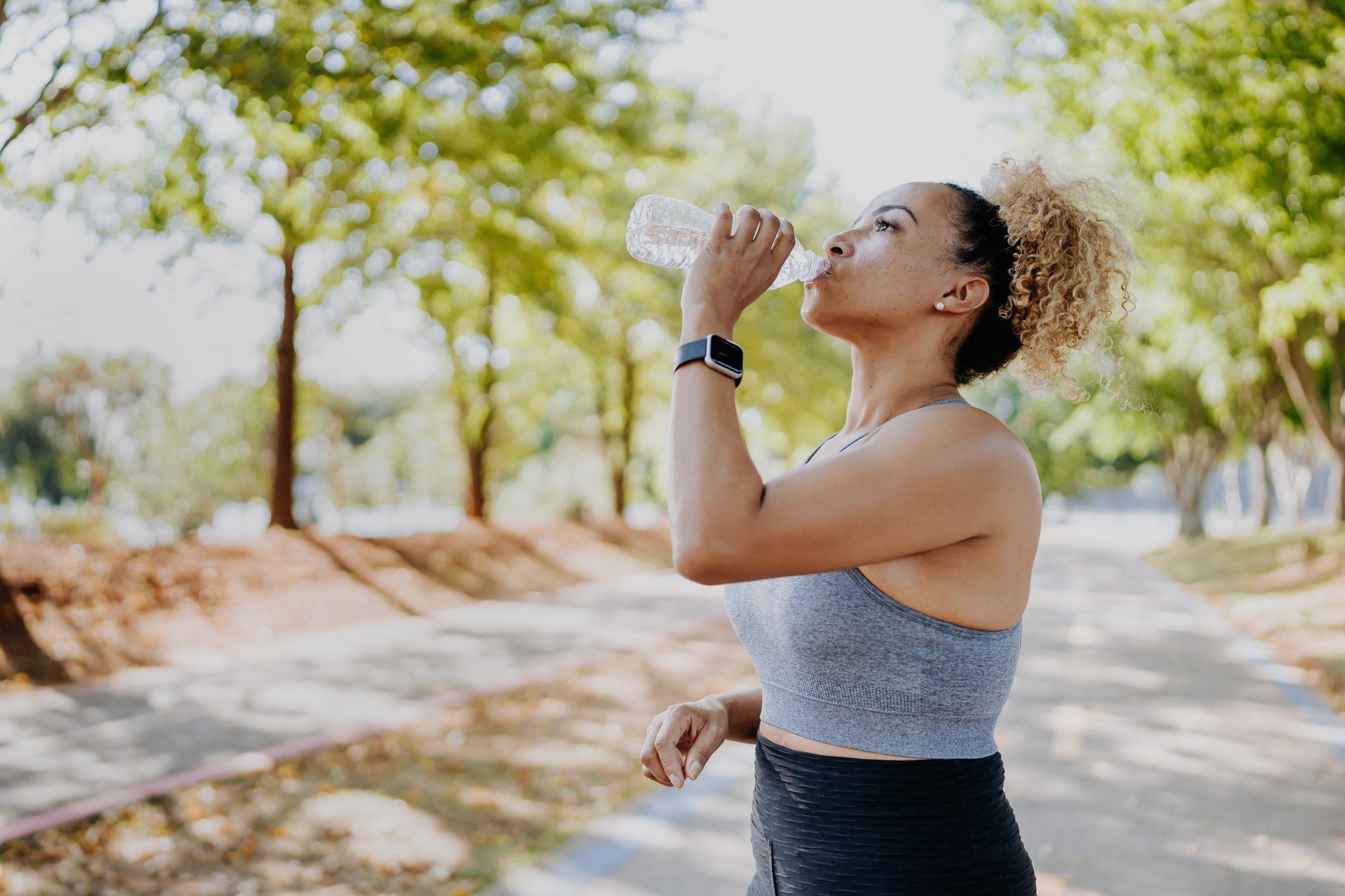 Woman drinking water after a run outside