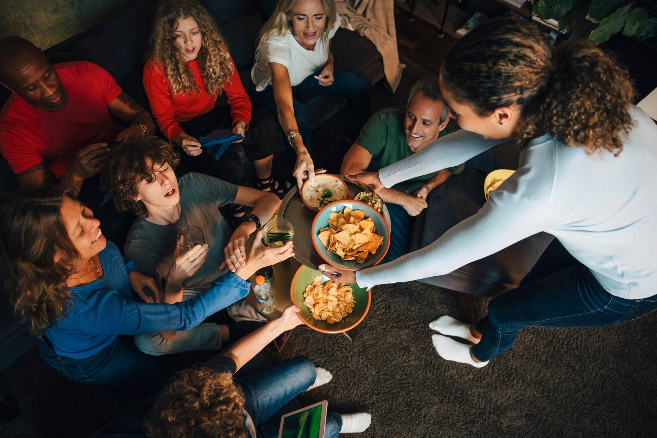 Family eating chips and packaged snacks at home, reflecting everyday shopping moments influenced by retail media
